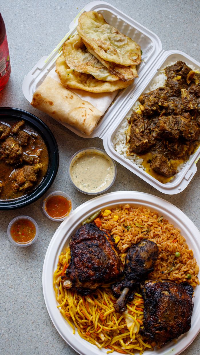 Contact An appetizing assortment of traditional African foods including rice, meats, and sauces on a table.